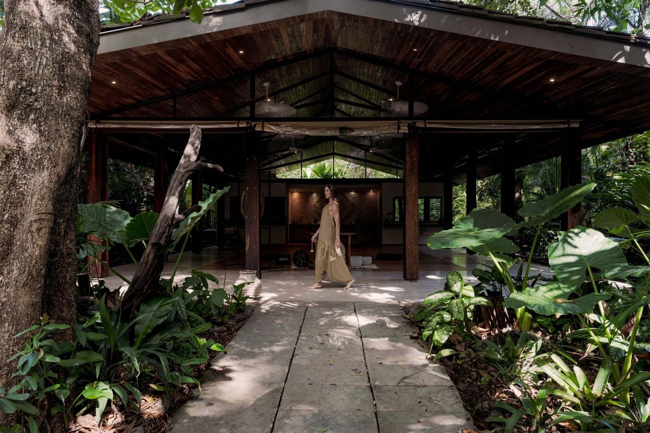 A woman walks towards the entrance of a covered walkway at Cala Luna Boutique Hotel.