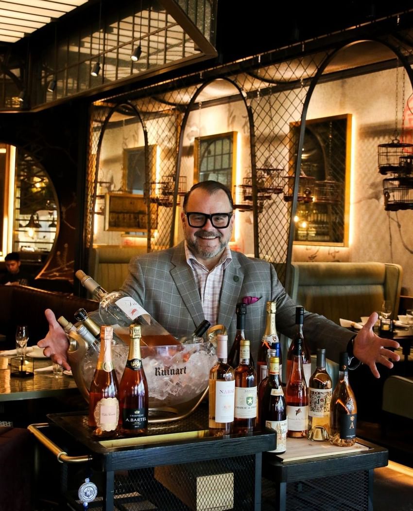 Man in glasses standing behind a tray of wine bottles at Paradox Vancouver