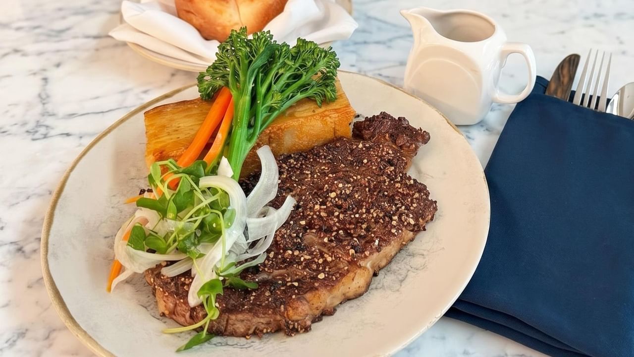 Steak with roasted vegetables and fresh greens.