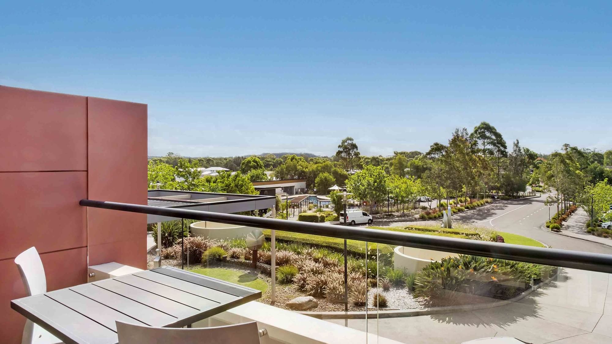 View from a Standard Room balcony overlooking a landscaped area with trees at Mercure Kooindah Waters