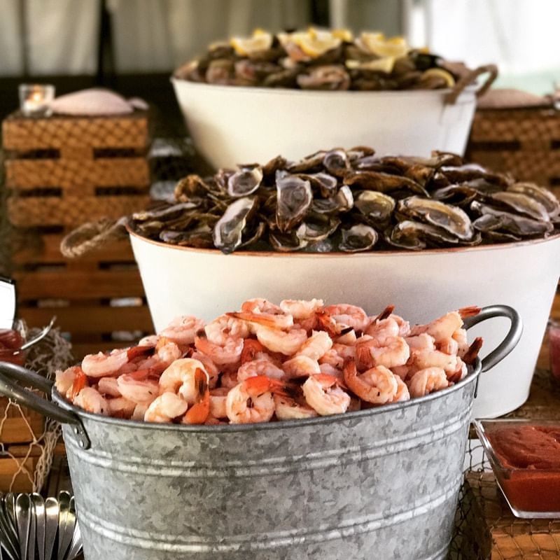 Tiered seafood display with shrimp in galvanized bucket and clams in white bowls at Aramark Chauncey Conference Center