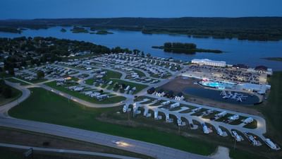 Aerial view of a riverside RV campground featuring numerous parked RVs and a pool area at Off Shore Resort