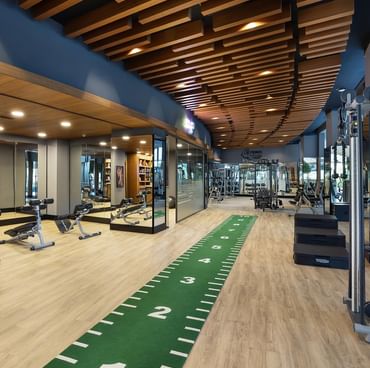 Titanic Luxury Collection Bodrum’da ahşap zeminli, modern ekipmanlarla donatılmış spor salonu.