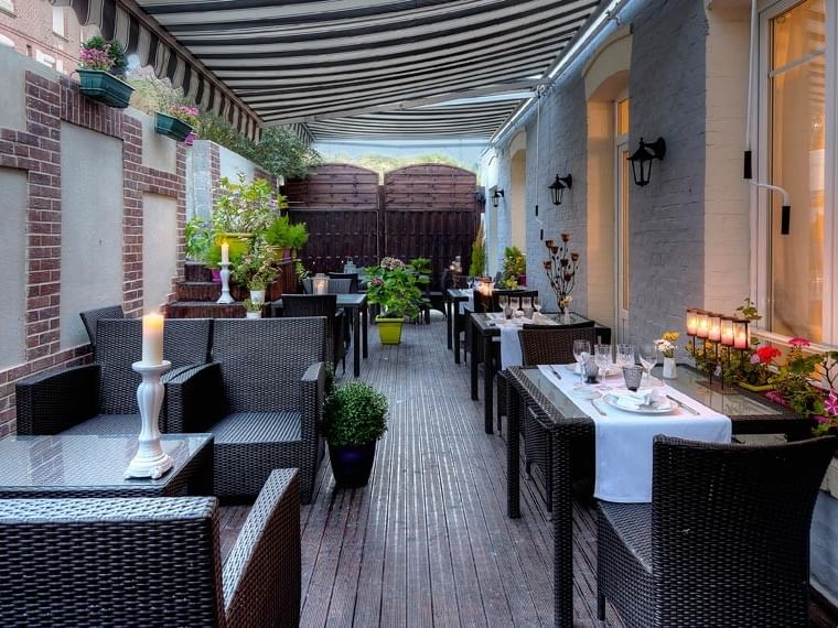Terrasse extérieure élégante avec tables et chaises à l'Hôtel Villa Aultia.