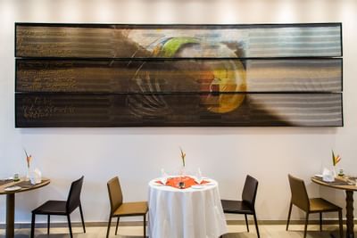 restaurants tables next to a big painting