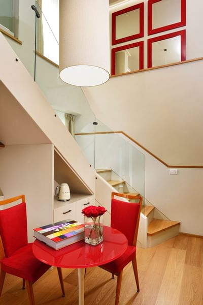 Red color round table with two chairs at Grand Hotel Minerva