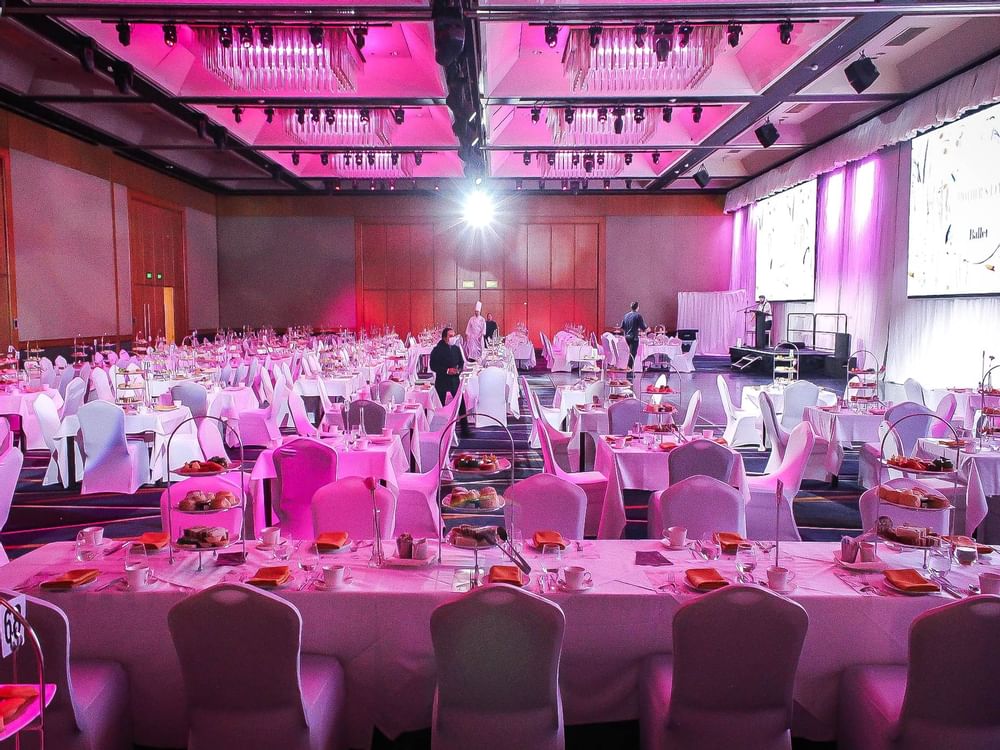 A spacious banquet hall illuminated with soft pink lighting in Ballroom Le Grand at Sofitel Brisbane Central
