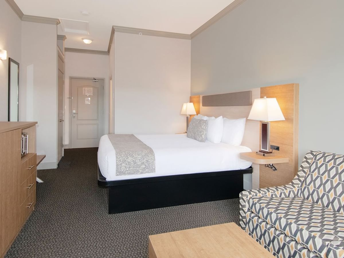 Hotel room with king bed, TV, mirror, sofa bed, and coffee table