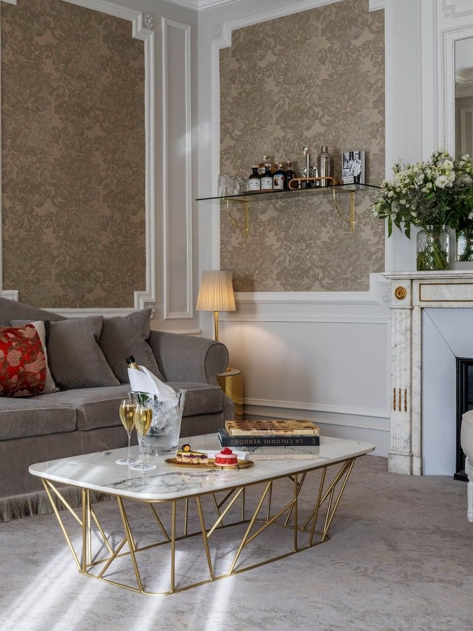 Sofa placed by a gold-legged coffee table by a fireplace in Prestige Suite – Rue de la Paix View at Hotel Westminster Paris