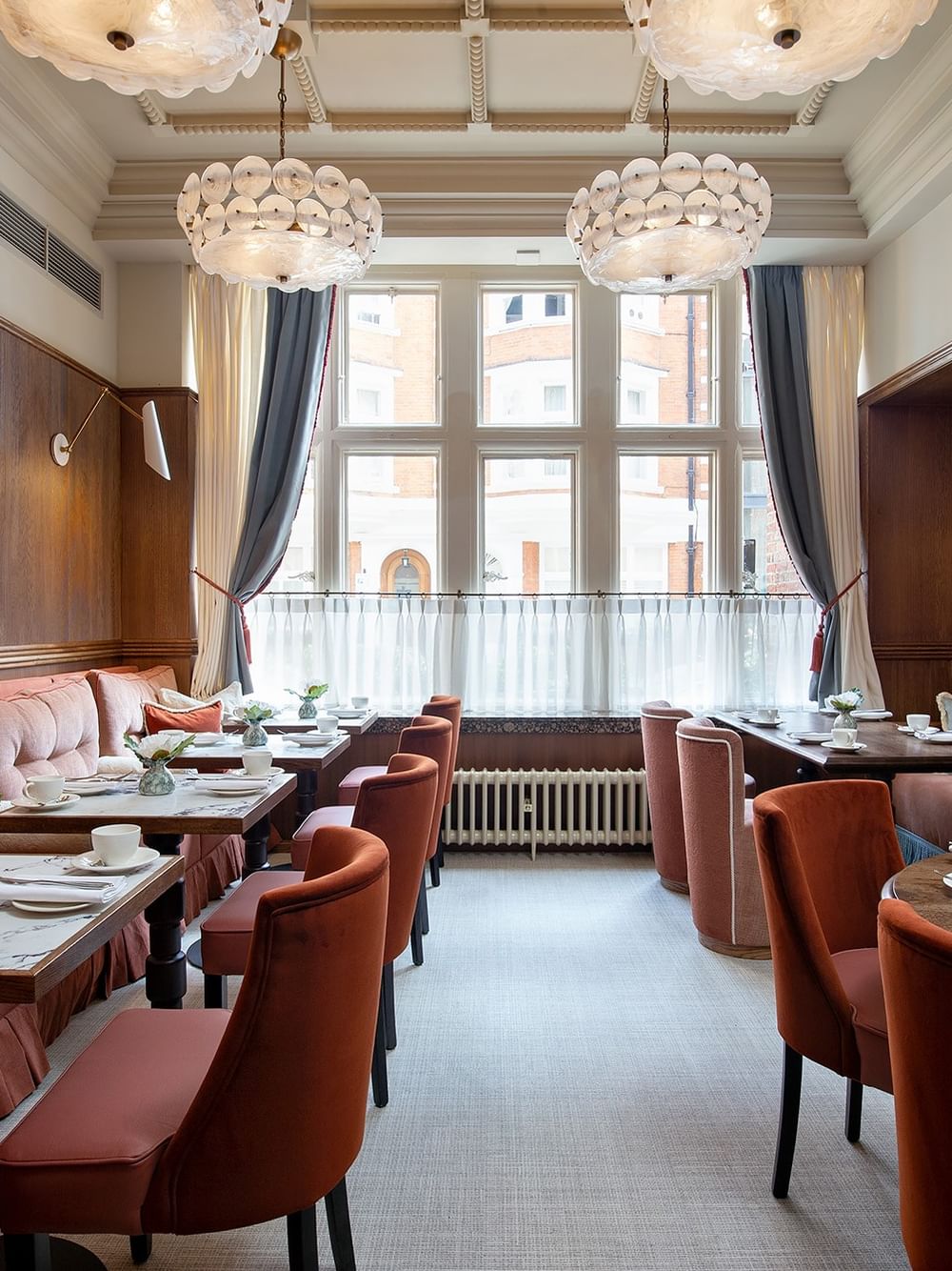 Interior of a restaurant with tables set for British Afternoon Tea at The Capital Hotel, Apartments & Townhouse in London