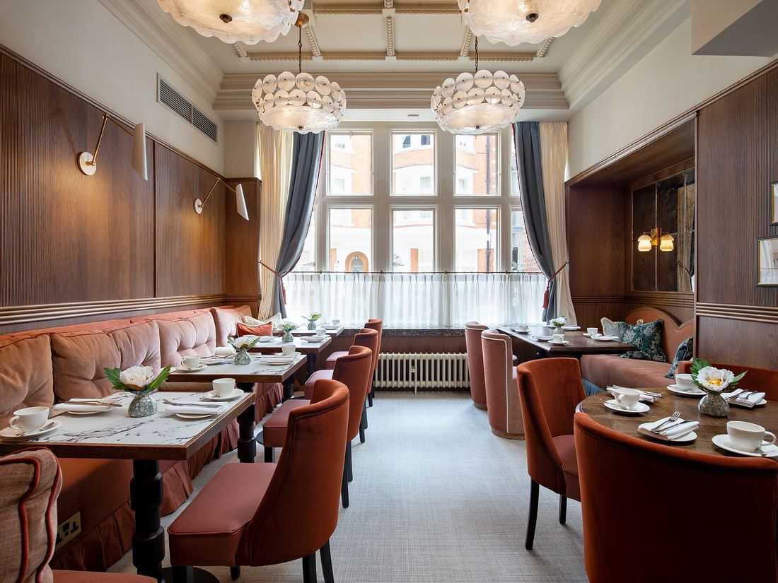 Interior of a restaurant with tables set for British Afternoon Tea at The Capital Hotel, Apartments & Townhouse in London