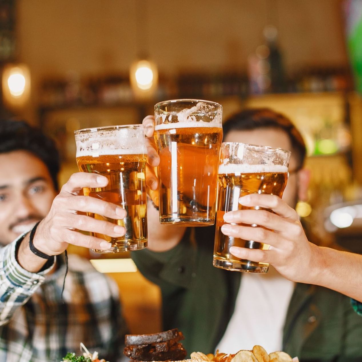 Three men cheer beer in Frankie Farell Irish Pub at Lake Buena Vista Resort Village & Spa