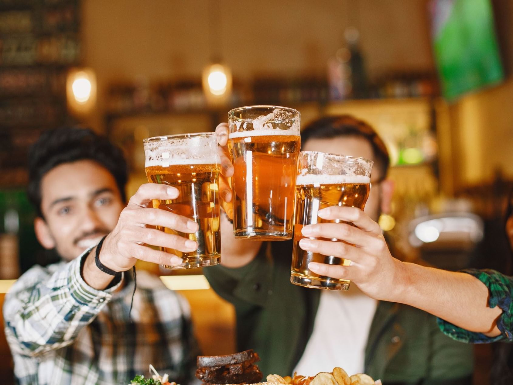 Three men cheer beer in Frankie Farell Irish Pub at Lake Buena Vista Resort Village & Spa