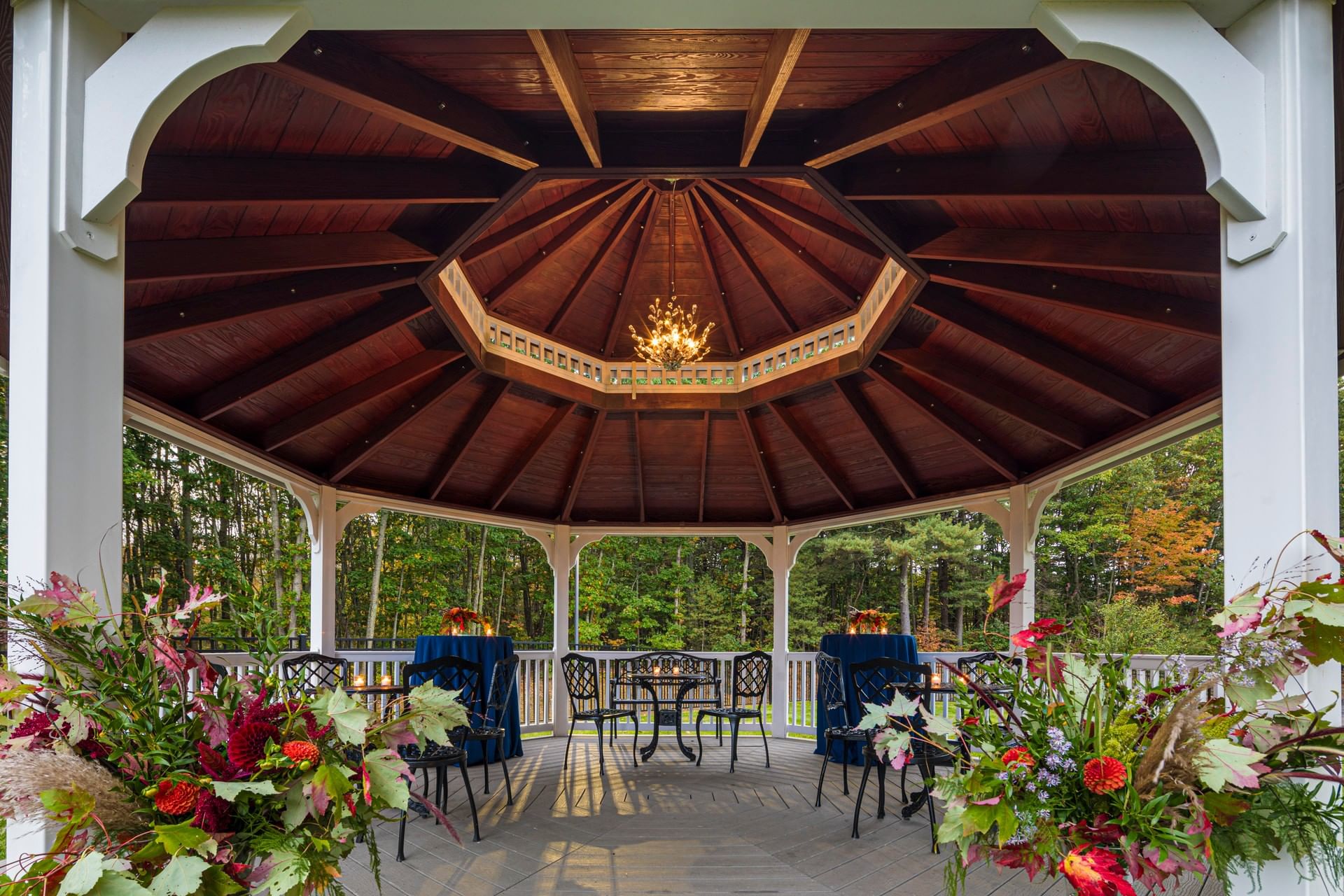 Wooden octagonal gazebo decorated with floral arrangements and cocktail seating at Sable Oaks Weddings and Events