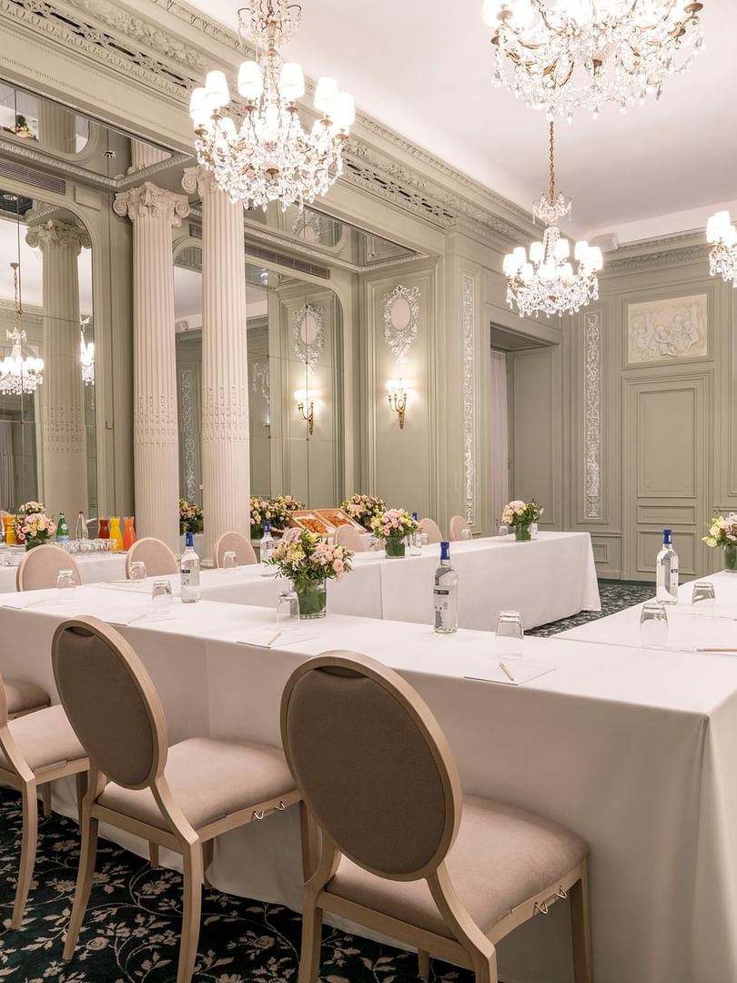 La salle de réunion Récamier, élégamment décorée avec des tables, des chaises et des lustres blancs, à l'Hôtel Westminster - Paris.