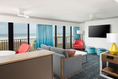TV and seating in the living area of Florida Conch Suite with carpeted floors at Bilmar Beach Resort