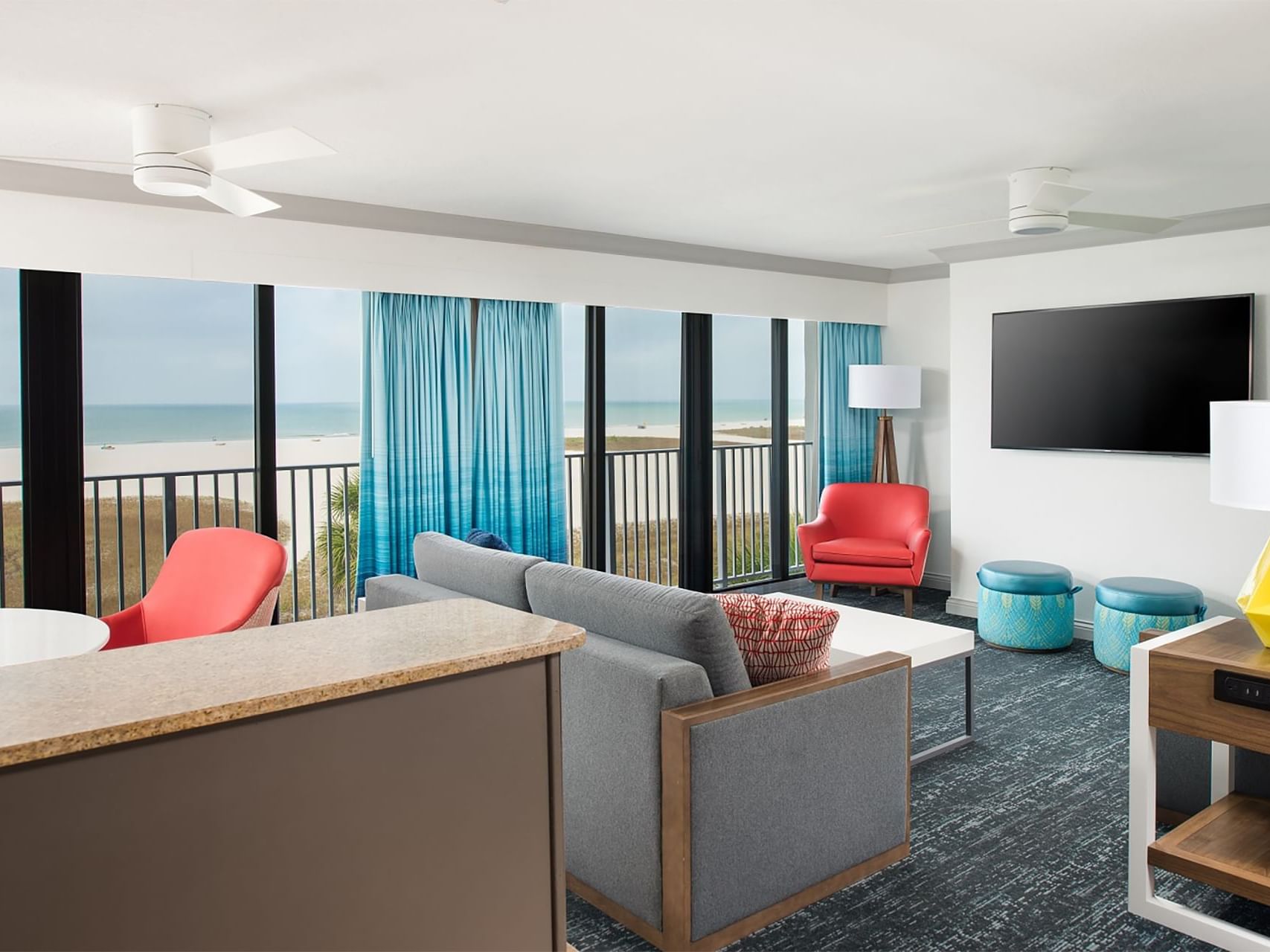 TV and seating in the living area of Florida Conch Suite with carpeted floors at Bilmar Beach Resort