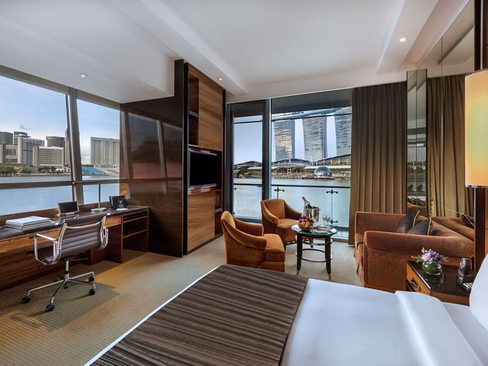 Bay View Corner Room with king bed and living area at The Fullerton Bay Hotel