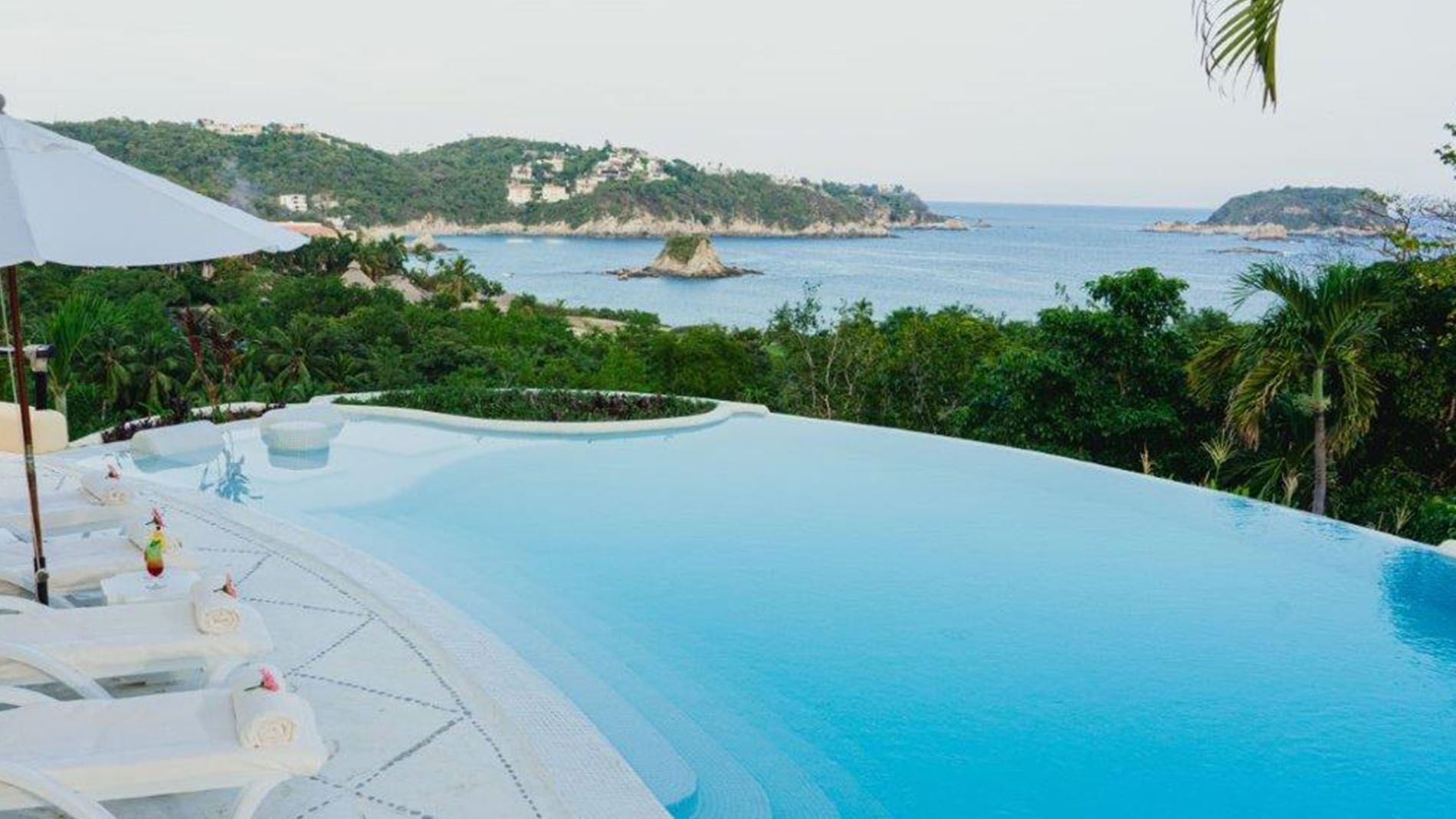 King Presidential Suite infinity pool  overlooking the turquoise ocean and lush coastal greenery at Quinta Real Huatulco