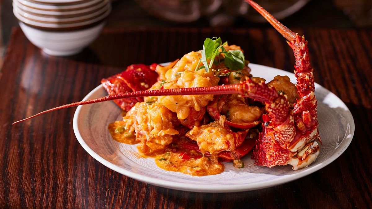 Lobster dish with a rich sauce on a plate, garnished with herbs served in Silks Restaurant at Crown Hotel Melbourne