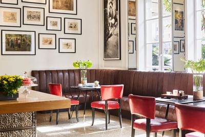 Opera Bar corner with framed art on the wall, plush brown seating and red chairs at Park Hyatt Saigon