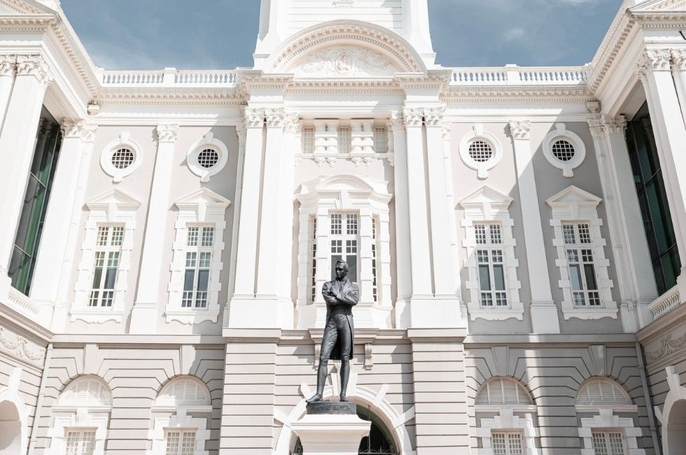 Statue of Sir Stamford Raffles standing outside the neoclassical Victoria Theatre and Concert Hall near Grand Park City Hall