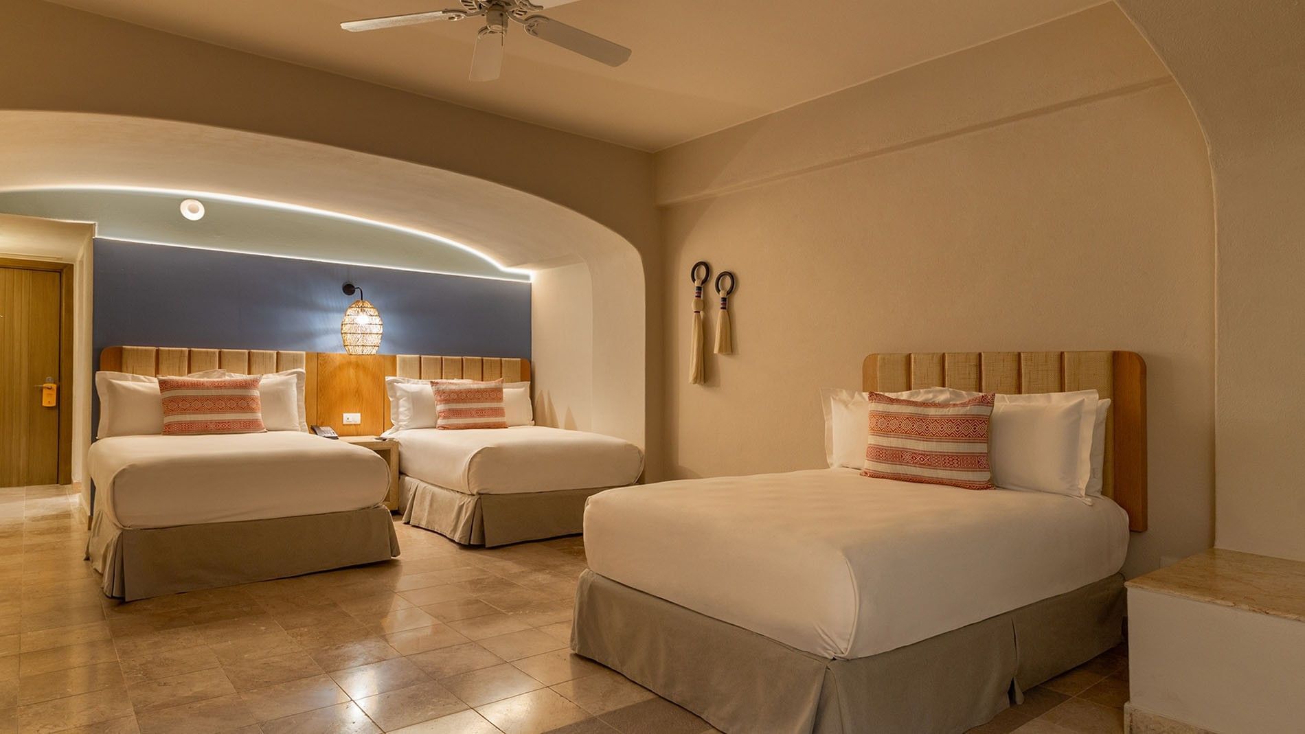 Three Double Beds Deluxe Superior with two beds, blue accent wall, and travertine flooring at Camino Real Acapulco Diamante