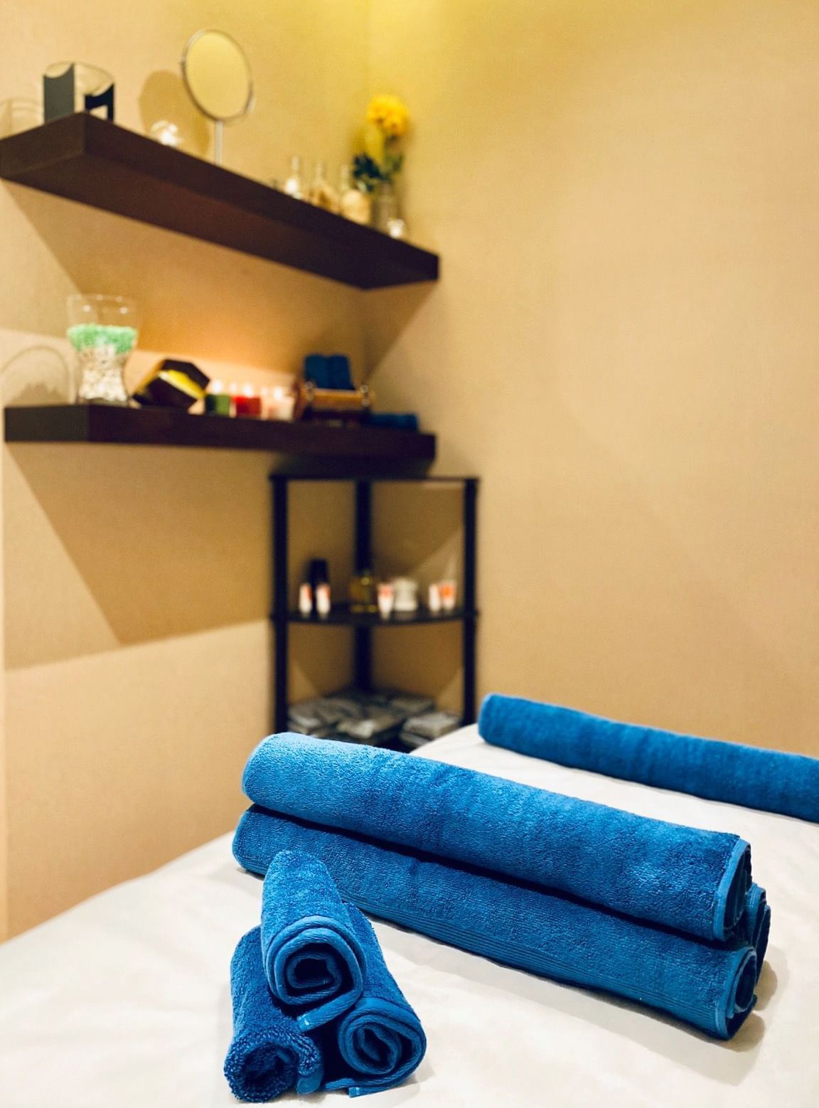 Blue towels placed on a bed in Gold Spa at The Naviti by Warwick Dammam