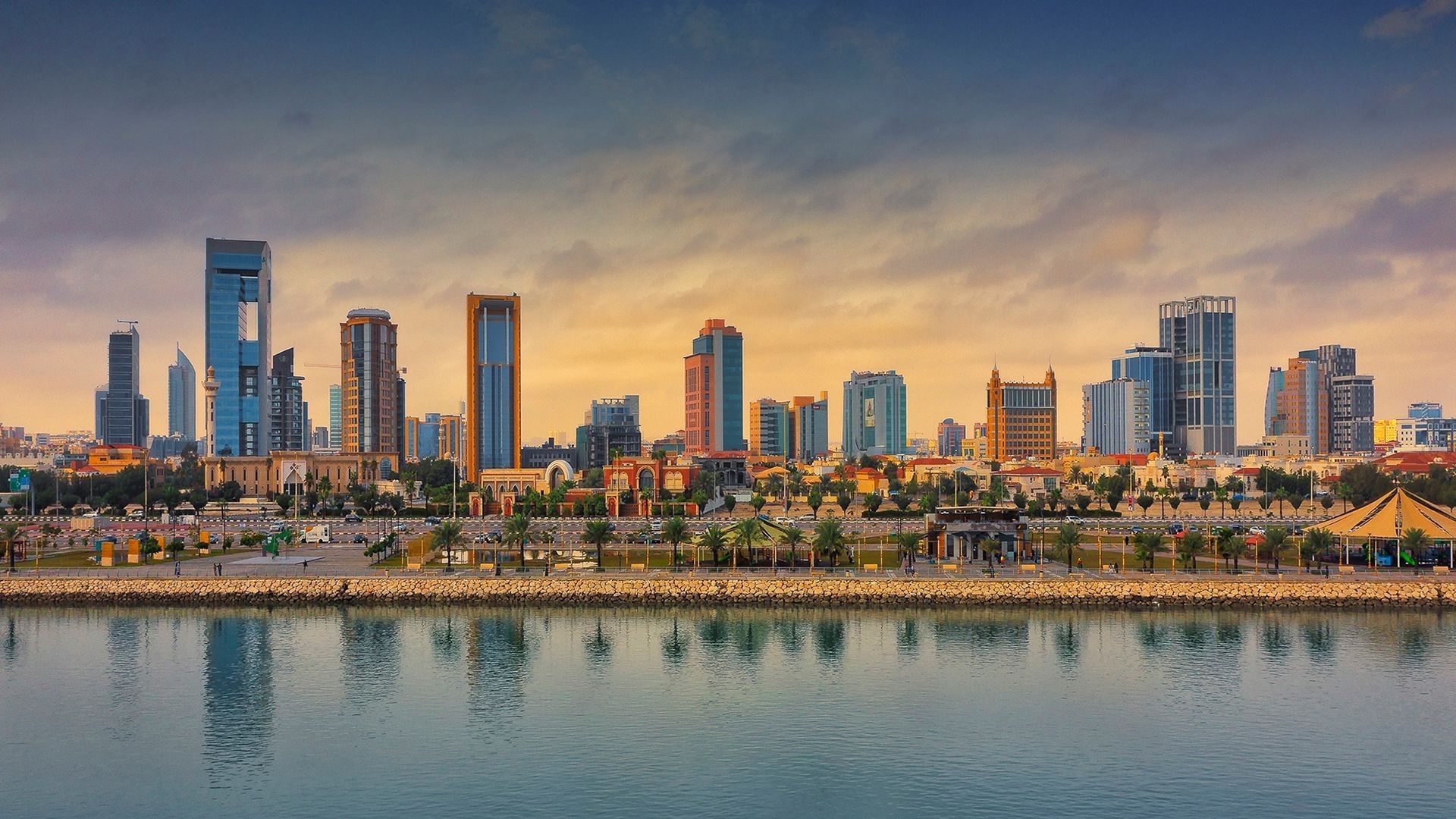 City skyline of Al-Khobar with palm trees by a calm body of water near Warwick Al Khobar