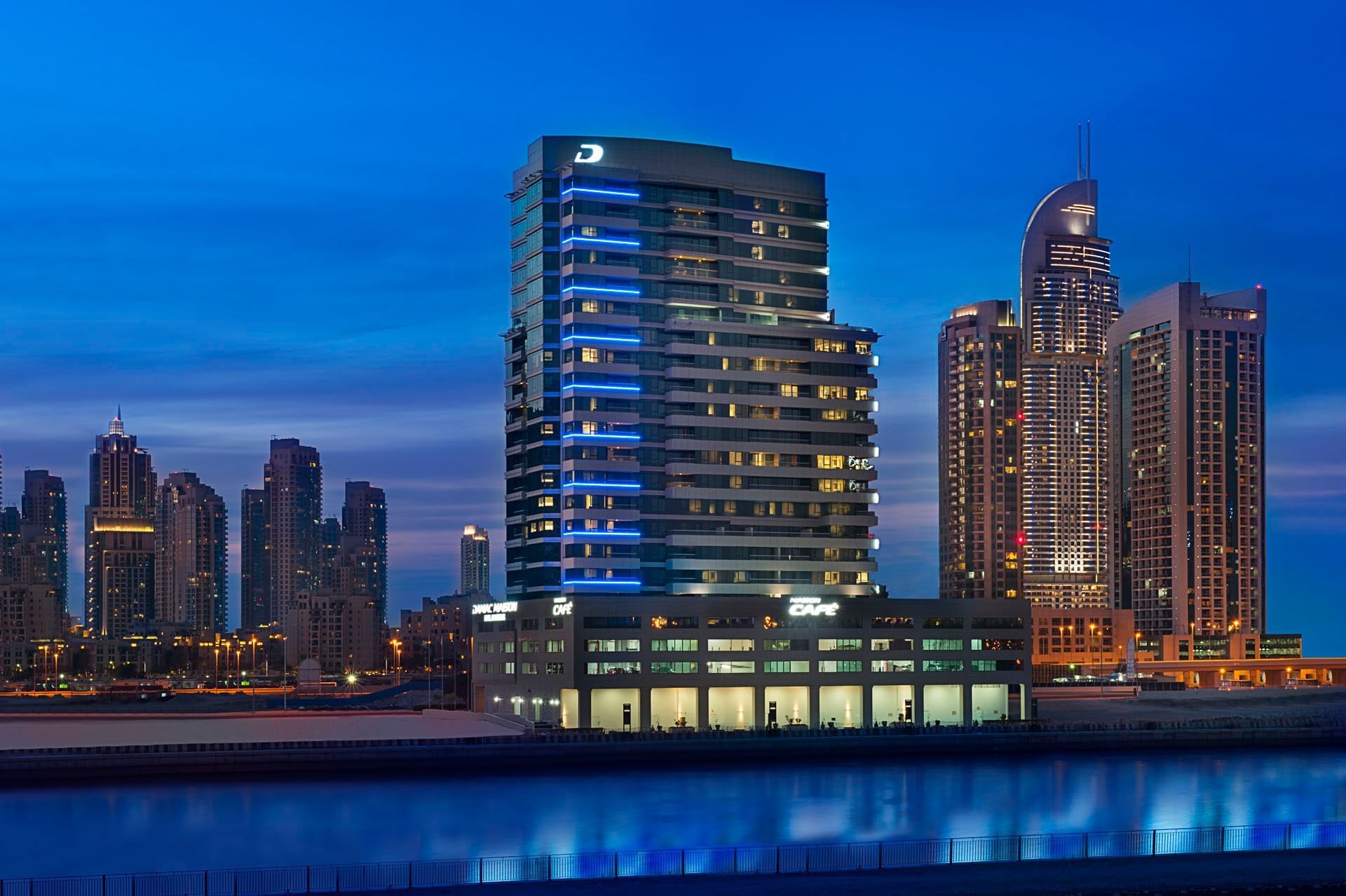 Elegant exterior of DAMAC Maison Canal Views in evening city lights featuring Premier 5-Star Hotel in Dubai