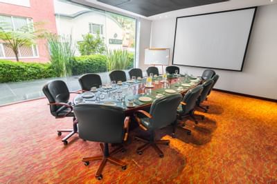 An arranged meeting room with black chairs and a table