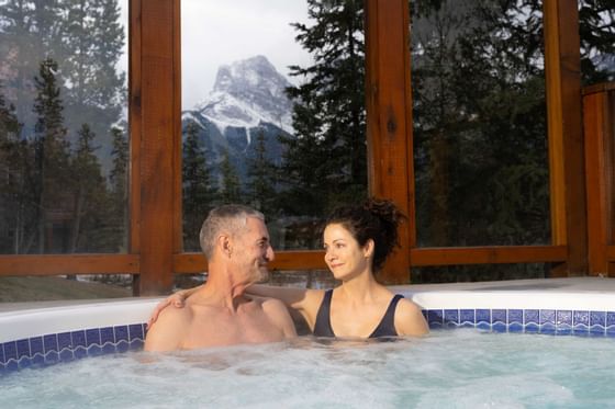 A couple bathing in a hot tub at Falcon Crest Lodge