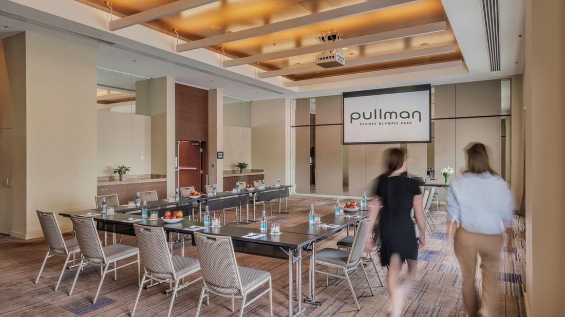Two women walk past the Echelon event room at Pullman Sydney Olympic Park.