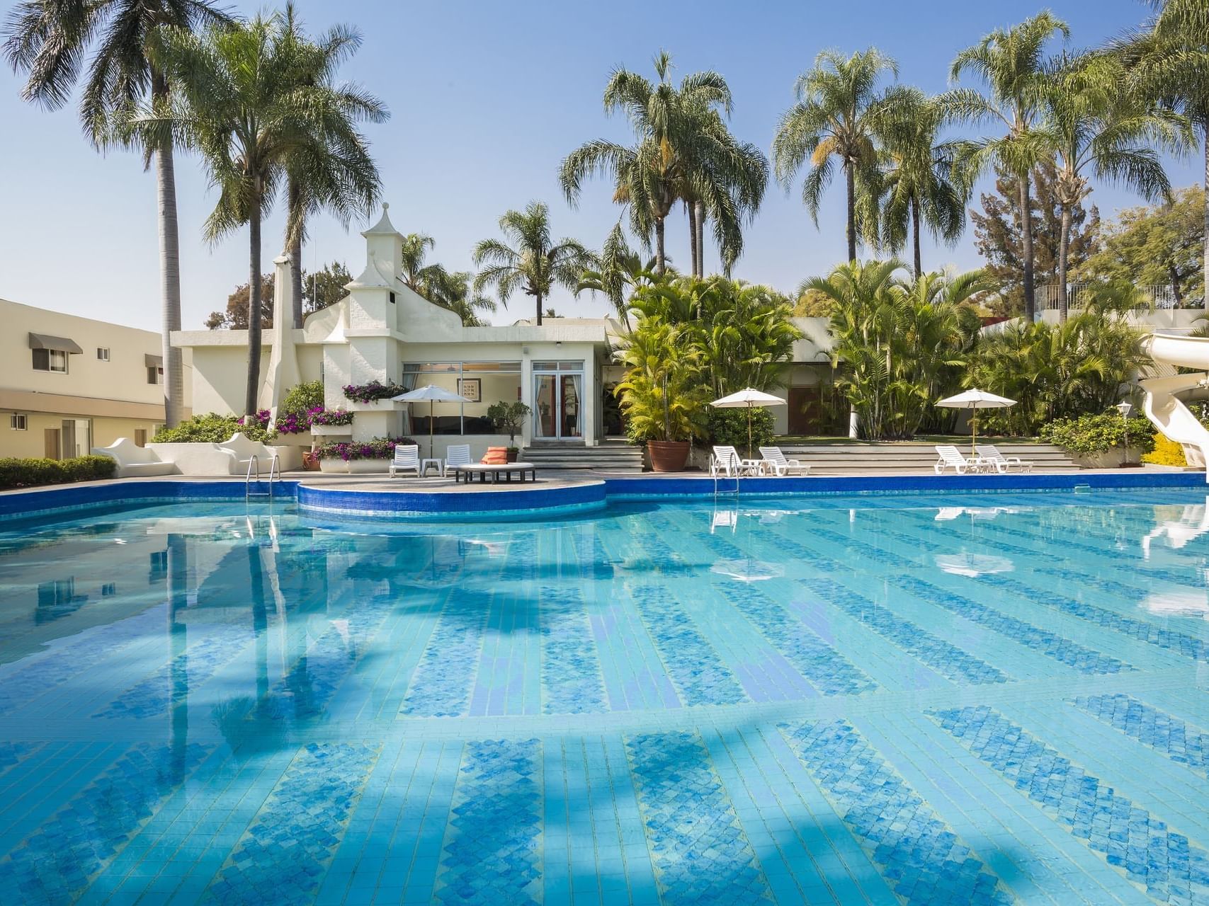 An outdoor swimming pool by a villa at Gamma Hotels