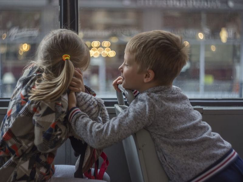 Two children in bus looking out window
