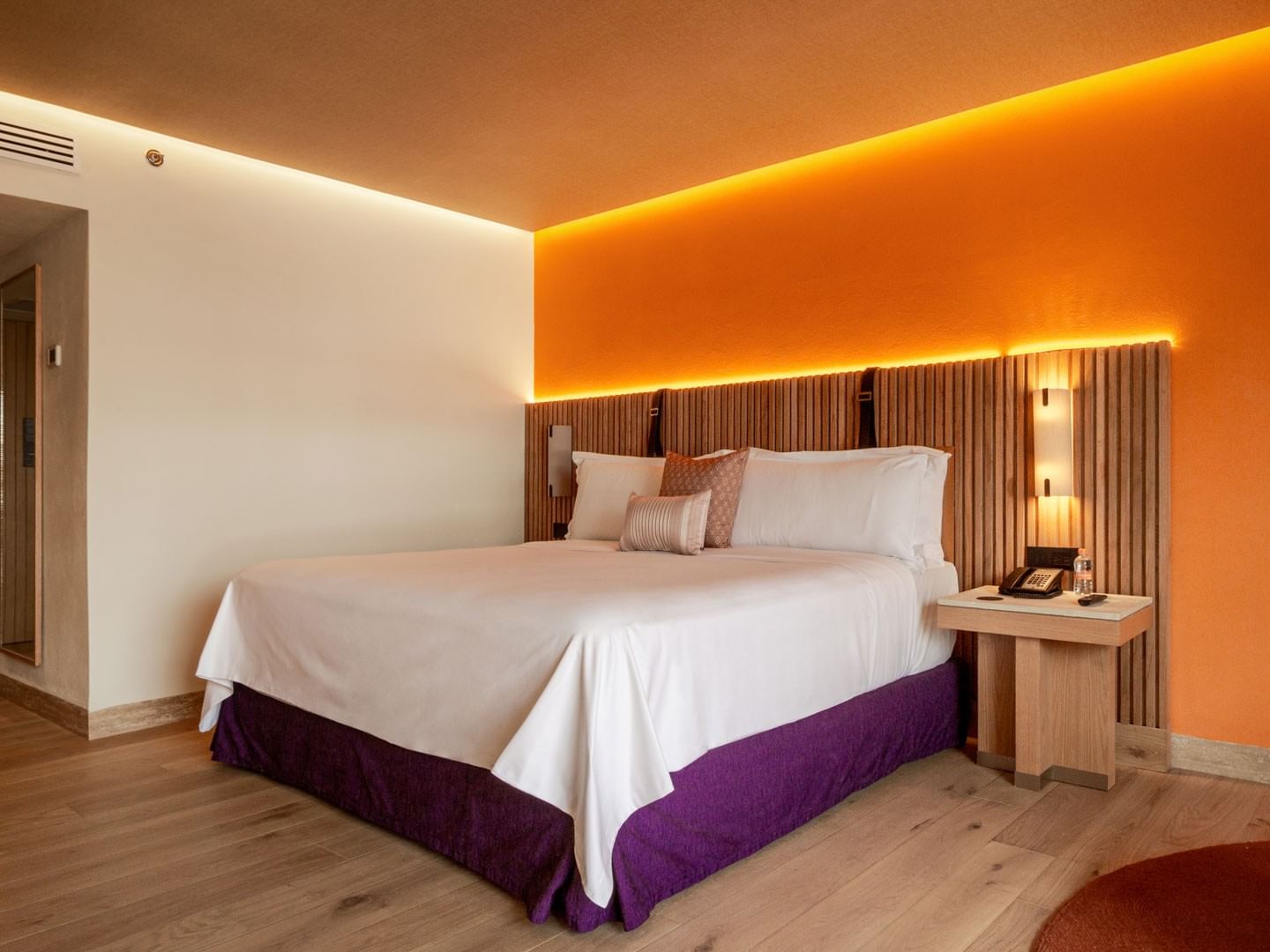 King Superior Camino Real Club with a slatted wood headboard and vibrant orange accents at Camino Real Polanco Mexico