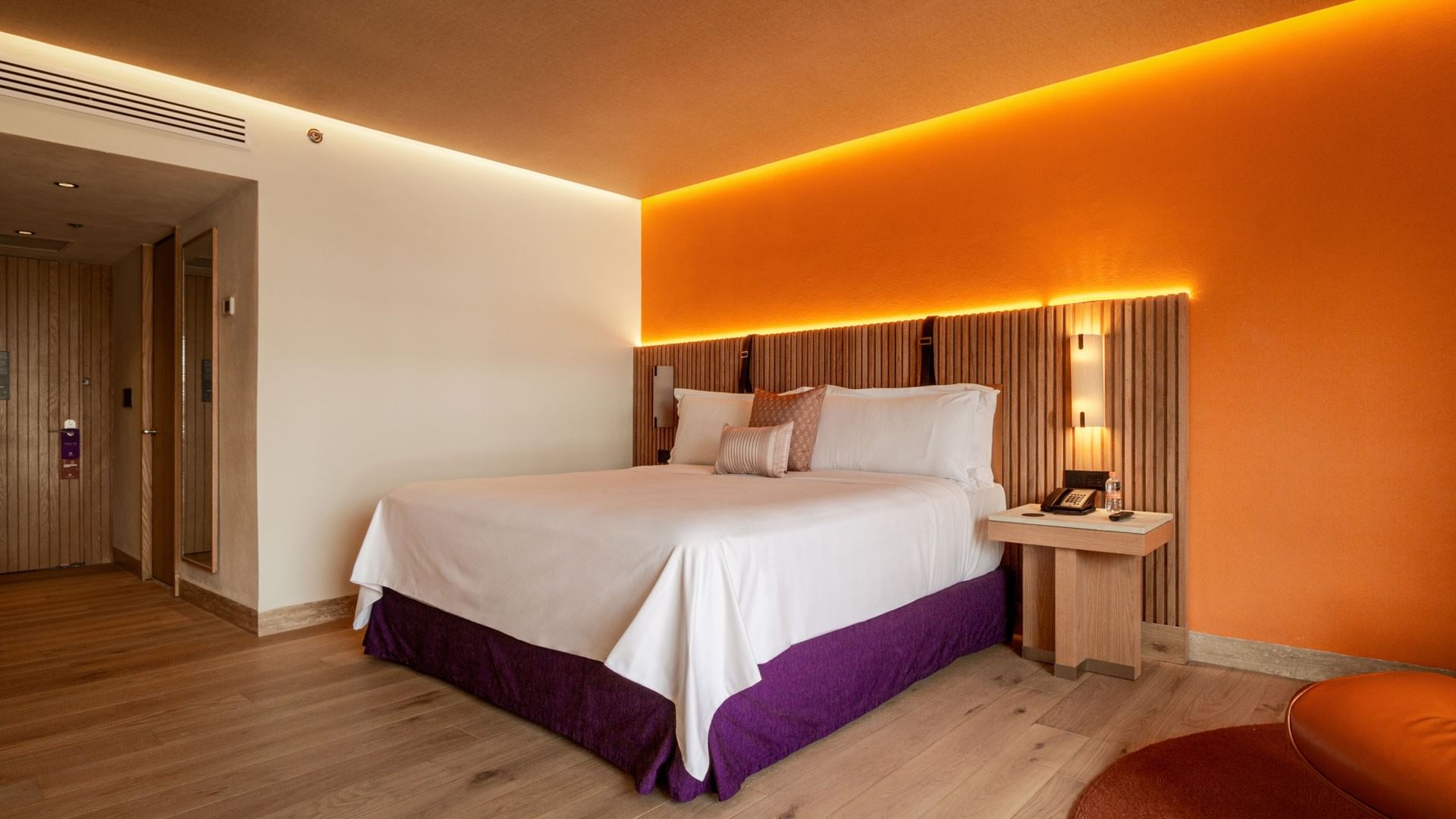 King Superior Camino Real Club with a slatted wood headboard and vibrant orange accents at Camino Real Polanco Mexico