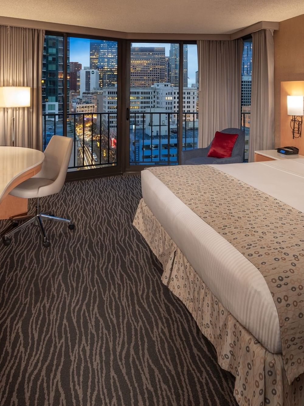 Modern hotel room with city views and a comfortable bed facing TV screen at Hotel Barsey by Warwick