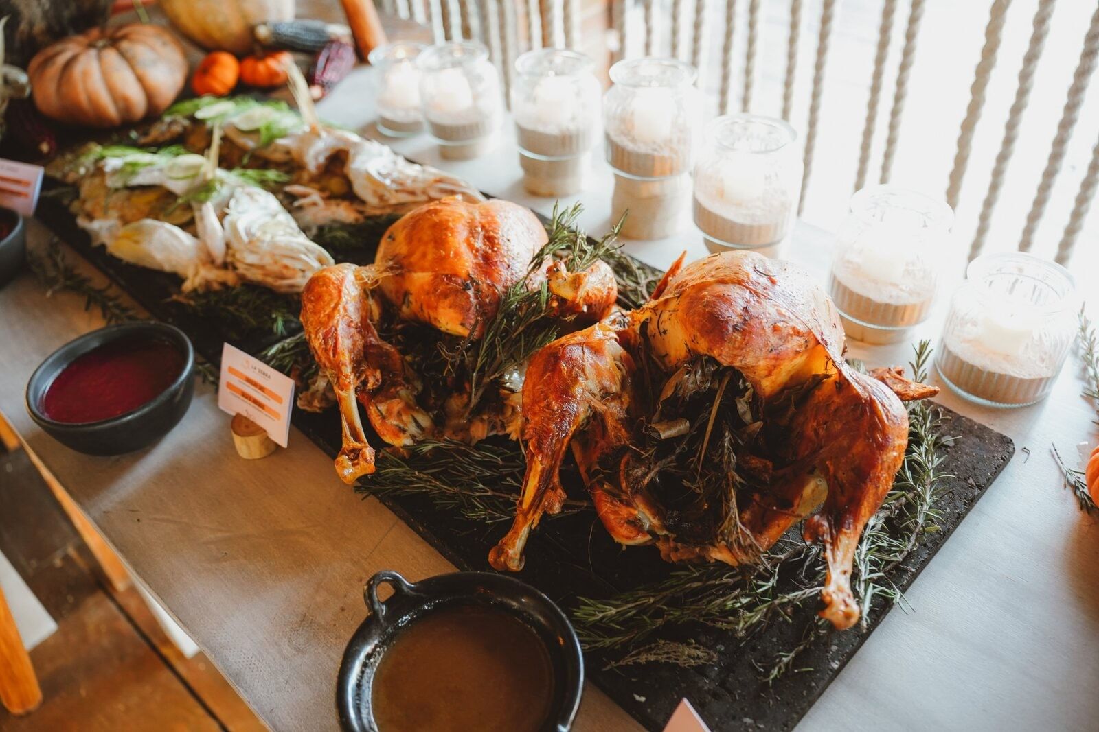 Roast turkeys arranged with herbs on a buffet table.