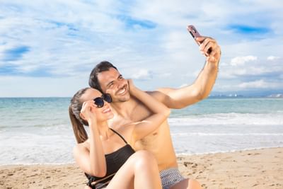 Couple getting selfie near the beach at Playa Los Arcos