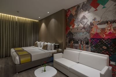 Two beds by a sofa in Studio Twin Room at Eastin Residences Vadodara