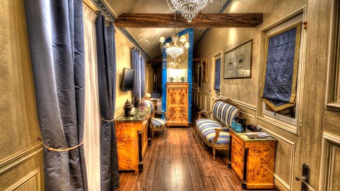 Couloir élégant avec mobilier classique et rideaux bleus à l'Hôtel Villa Aultia.