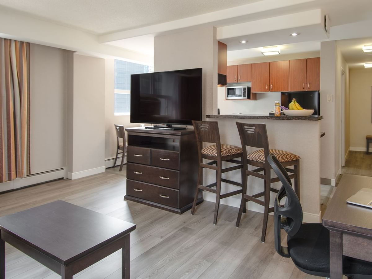 Hotel suite with TV, kitchen and living area