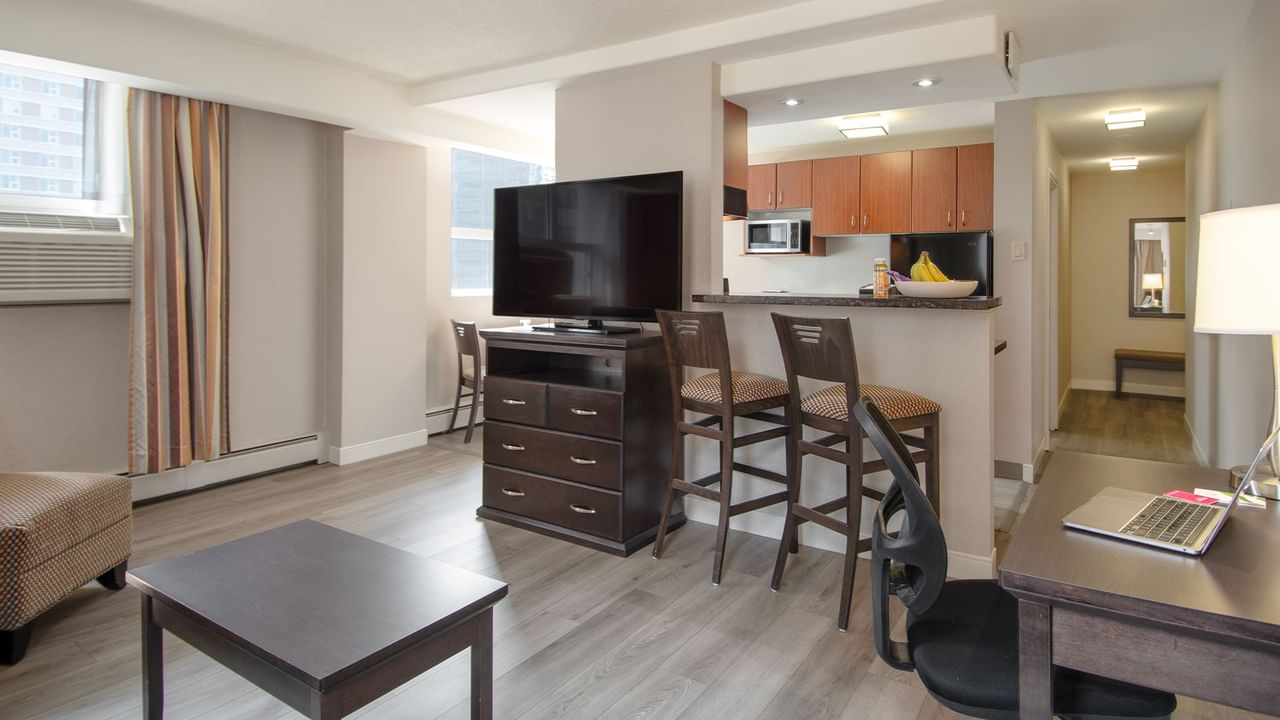 Hotel suite with TV, kitchen and living area