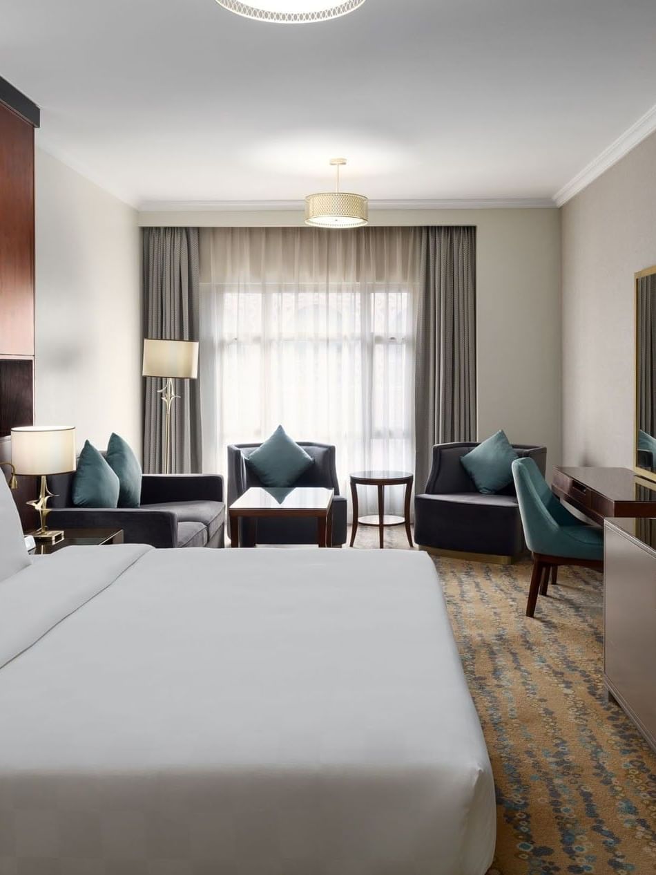 غرفة كينغ تنفيذية في فندق سجى ووريك المدينة، تضم سريرًا كبيرًا، منطقة جلوس أنيقة، مكتب عمل، وتلفاز بشاشة مسطحة بتصميم عصري وإضاءة طبيعية من نافذة واسعة.