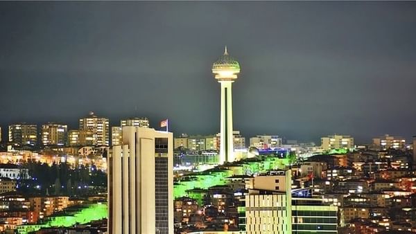 Atakule tower by city buildings under a dark night sky near Warwick Ankara