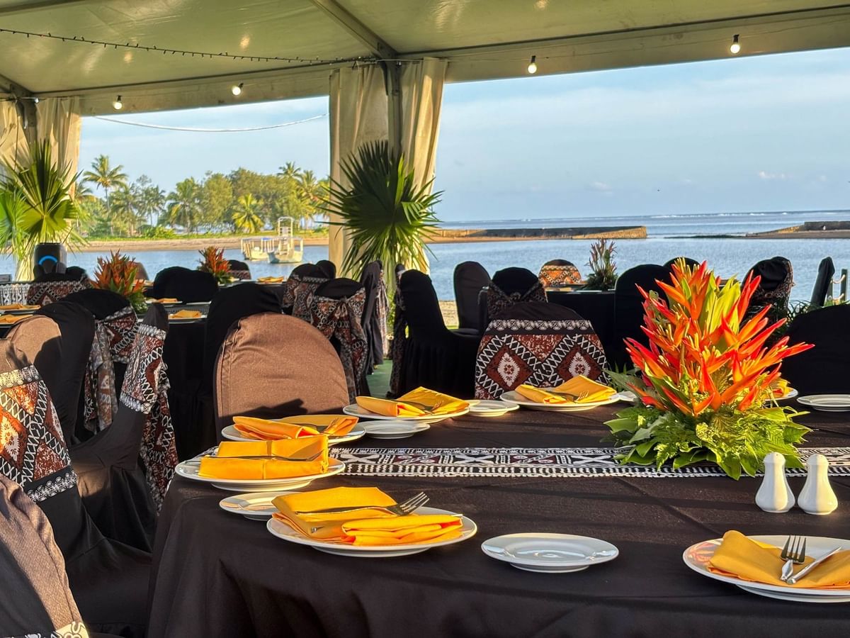 Elegant seaside dining setup with tropical decor and scenic ocean view at The Naviti Resort Fiji Coral Coast.