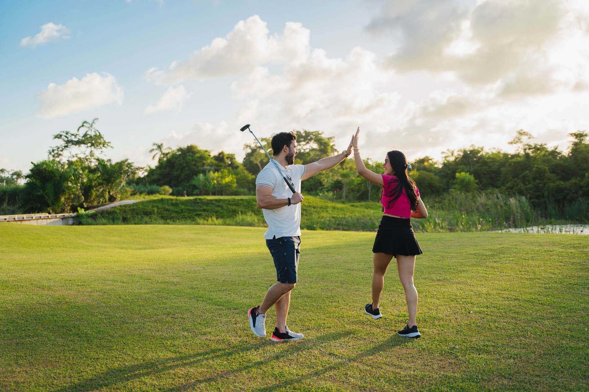 Couple giving high five on a golf course near Indura Beach & Golf Resort