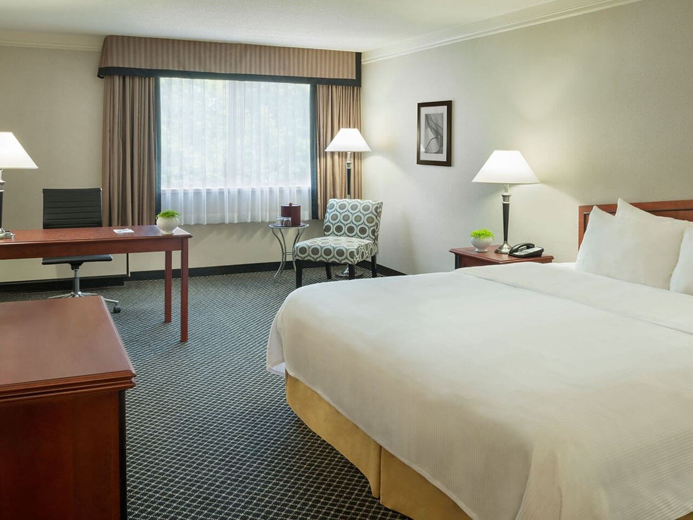 Bed in hotel room with desk and chair