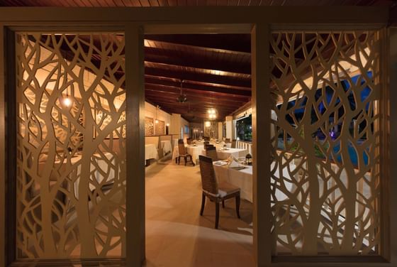 Decorative lattice screens frame a warmly lit restaurant interior at All Seasons Resort Europa